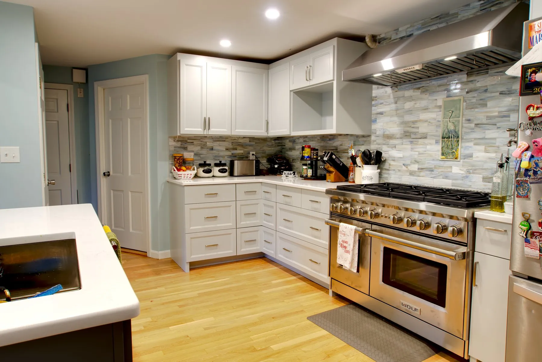 Renovated kitchen with white shaker cabinetry, glass tile backsplash, and a professional range — interior and real estate photography by Coonan Creative, Long Island NY